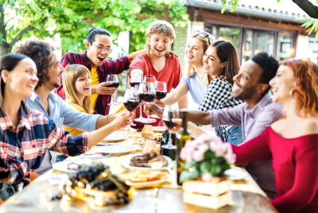 Happy friends having fun toasting wine out side - Young people sharing harvest together at farm house vineyard countryside - Youth life style concept - Shallow depth of field with focus on central guy